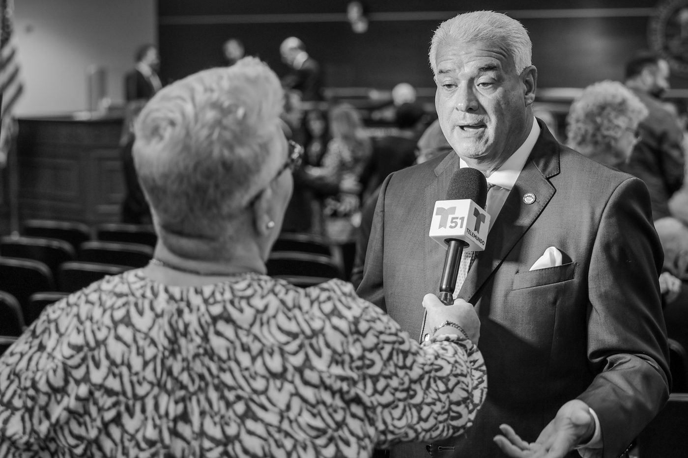 An official answers a television reporter&rsquo;s questions on camera.