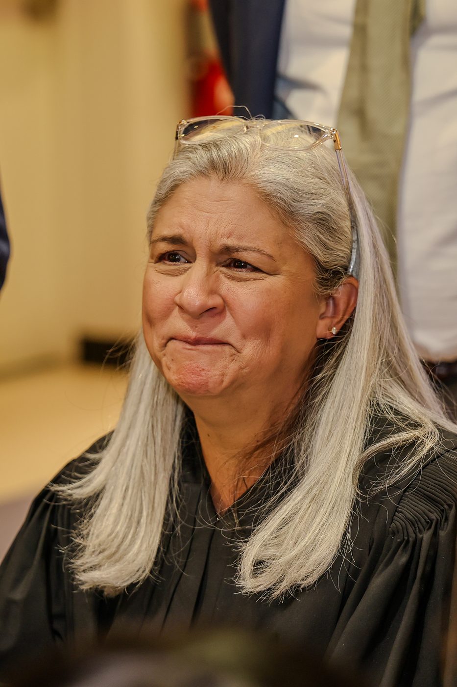 A judge listens from the bench during a courthouse ceremony.