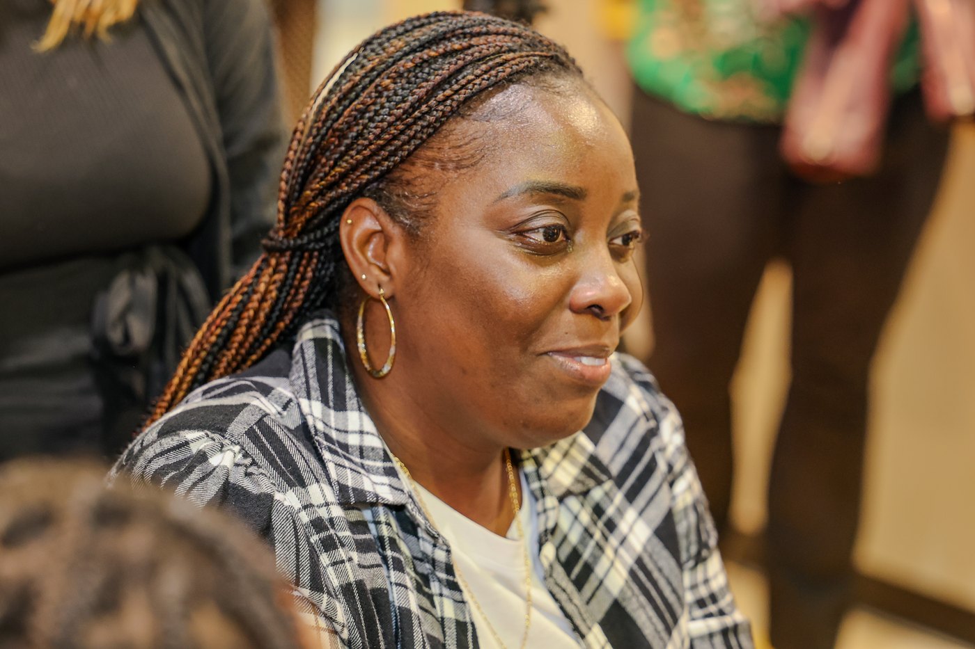 A woman listens intently during a community event.